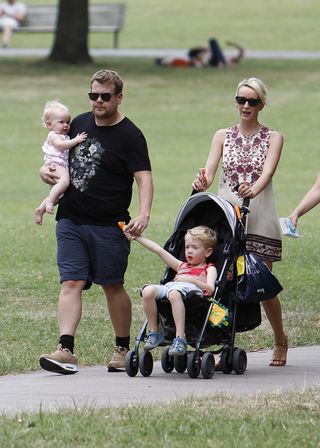 James Corden and his wife Jules and their children walking in a London park