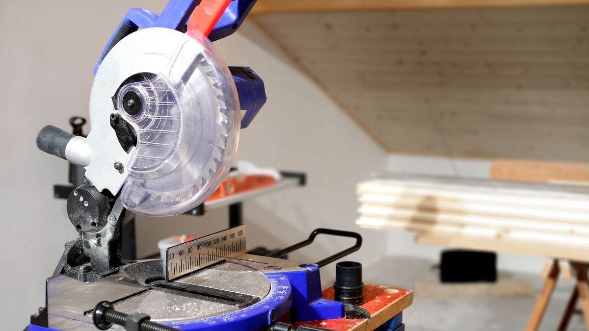 Blue mitre saw on work bench in loft