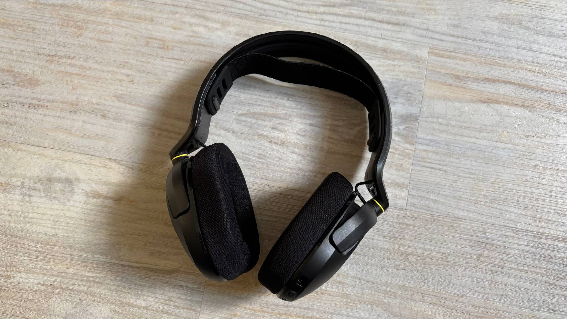Corsair HS35 v3 headset mid shot showing entire headset with no mic attached against a white hardwood floor