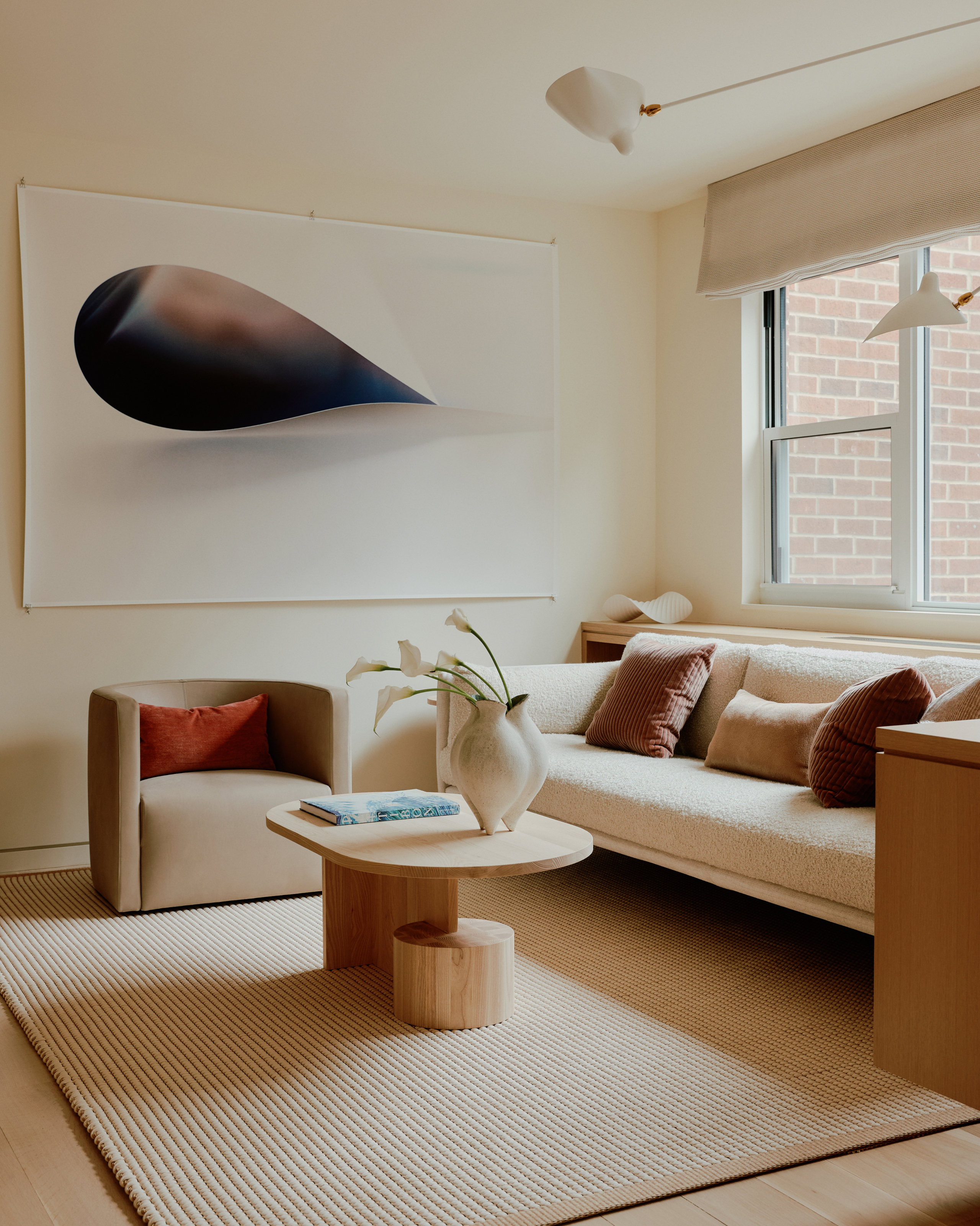 Cream living room with cream sofa, oak coffee table and abstract artwork