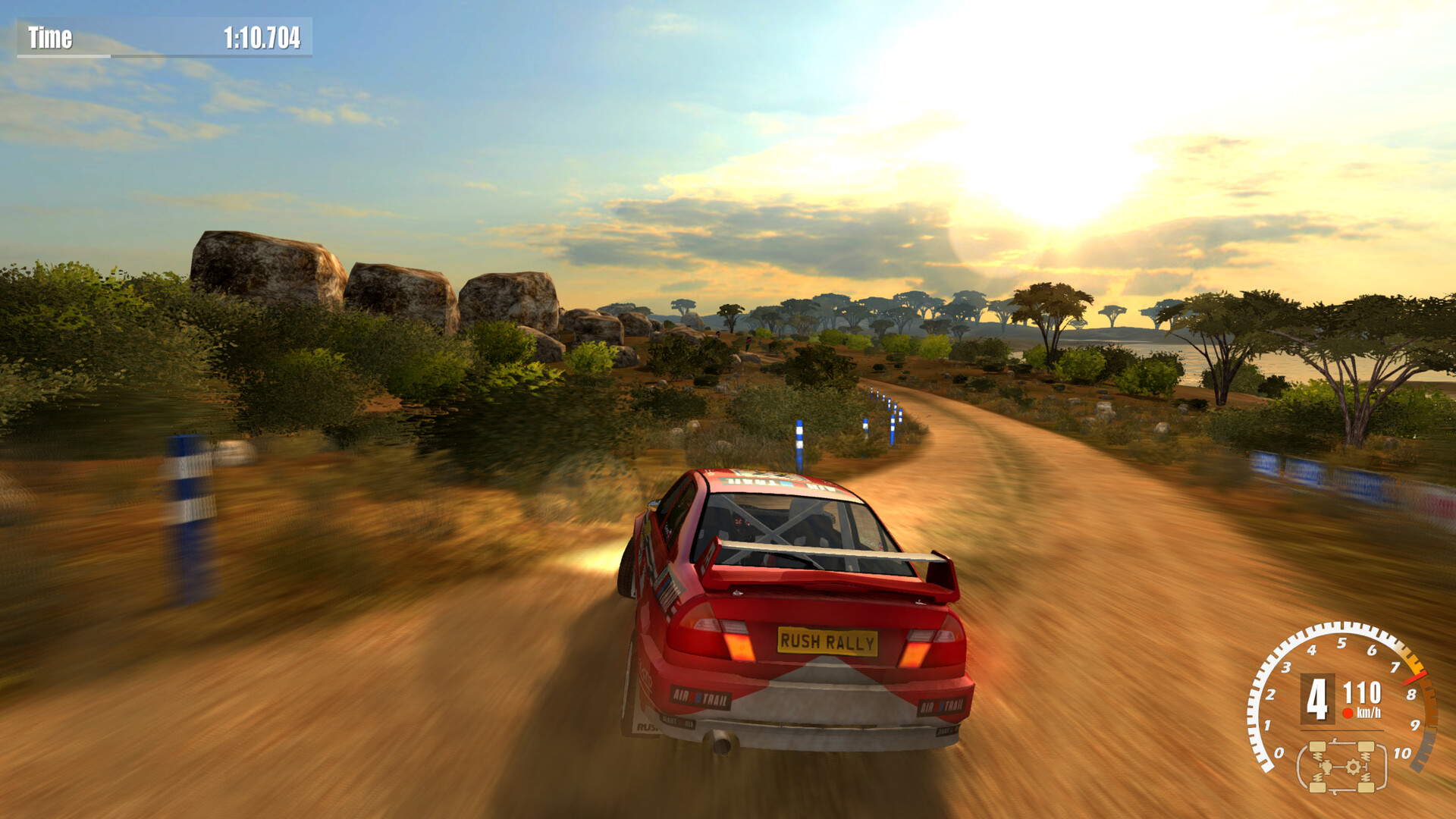 Red rally car on dirt, almost savanna track amid setting sun.