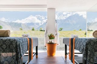 treatment tables in front of floor to ceiling windows with mountain view