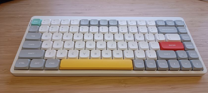 A white NuPhy Air75 V2 keyboard on a wooden desk