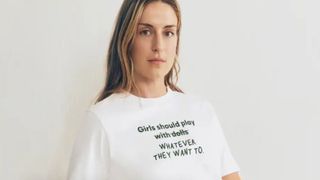 Woman in a white t-shirt that reads Girls should play with whatever they want to.