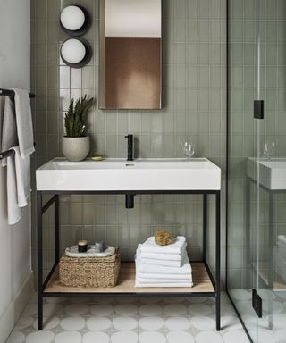 Gray-green tiled bathroom, white and black sinks, shower screen, wall lights, mirror
