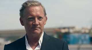 Daniel Lang (Douglas Henshall) viewed from the shoulders up, looking dapper in a tux - the horizon behind the character is out of focus