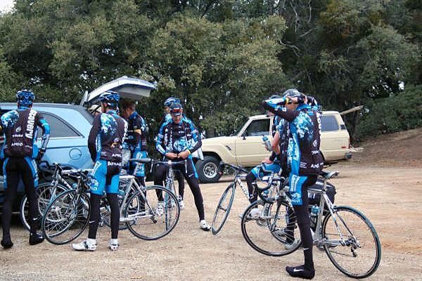 The riders rest at the top, Putting on more clothing and taking drinks.