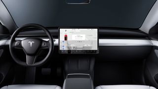 The dashboard inside the Tesla Model 3 showing the steering wheel and central display