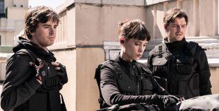 Thom (Freddie Highmore), Lorraine (Àstrid Bergès-Frisbey) and James (Sam Riley) survey the entrance to a bank vault they must enter without alerting hundreds of police standing by to arrest them.
