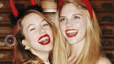 Two woman in Halloween costumes with horns