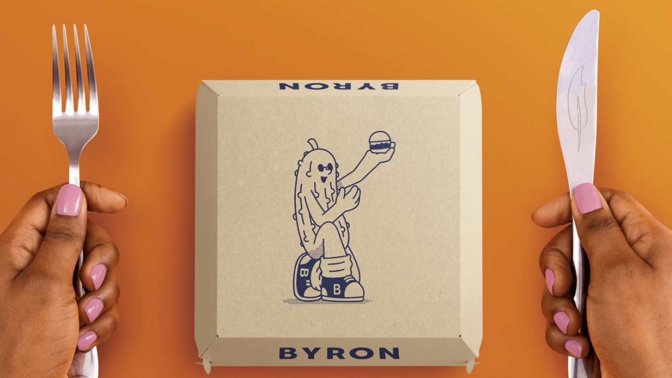 A burger box with a cartoon illustration of a gherkin holding a burger