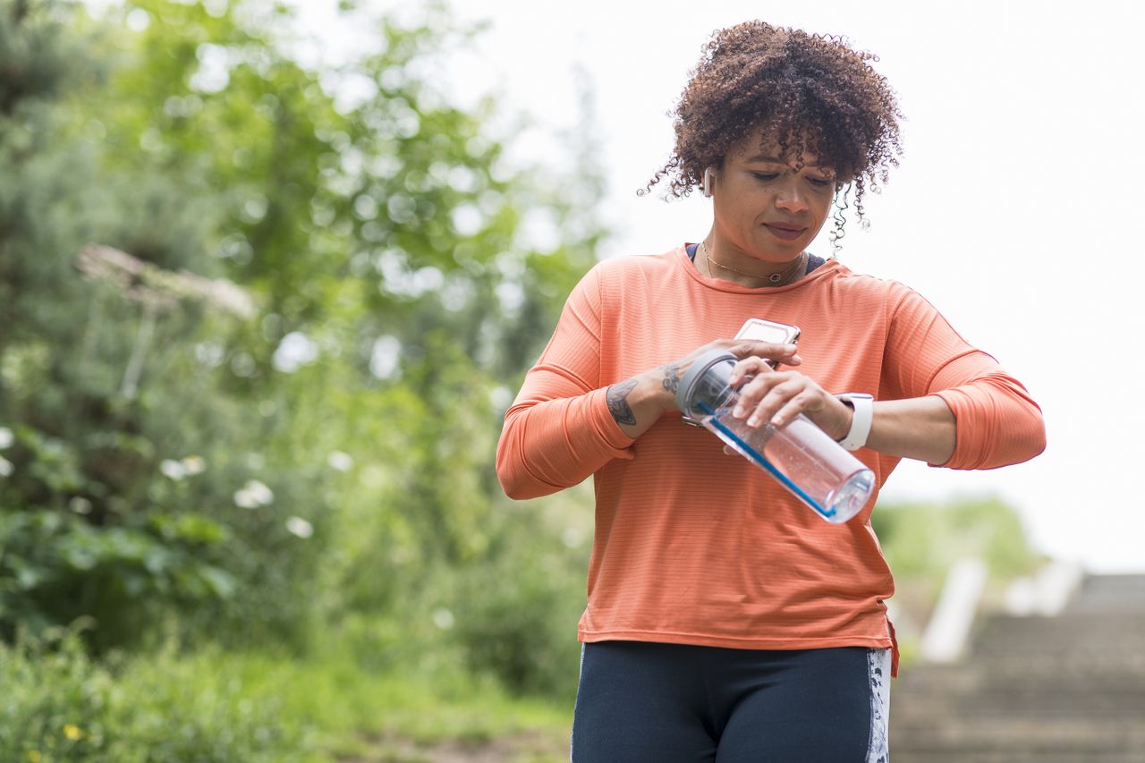 Woman checks her step count on a walk