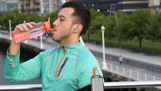 Man drinking from water bottle outside