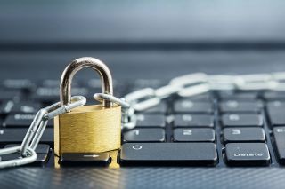 A lock and chain sitting on a laptop keyboard