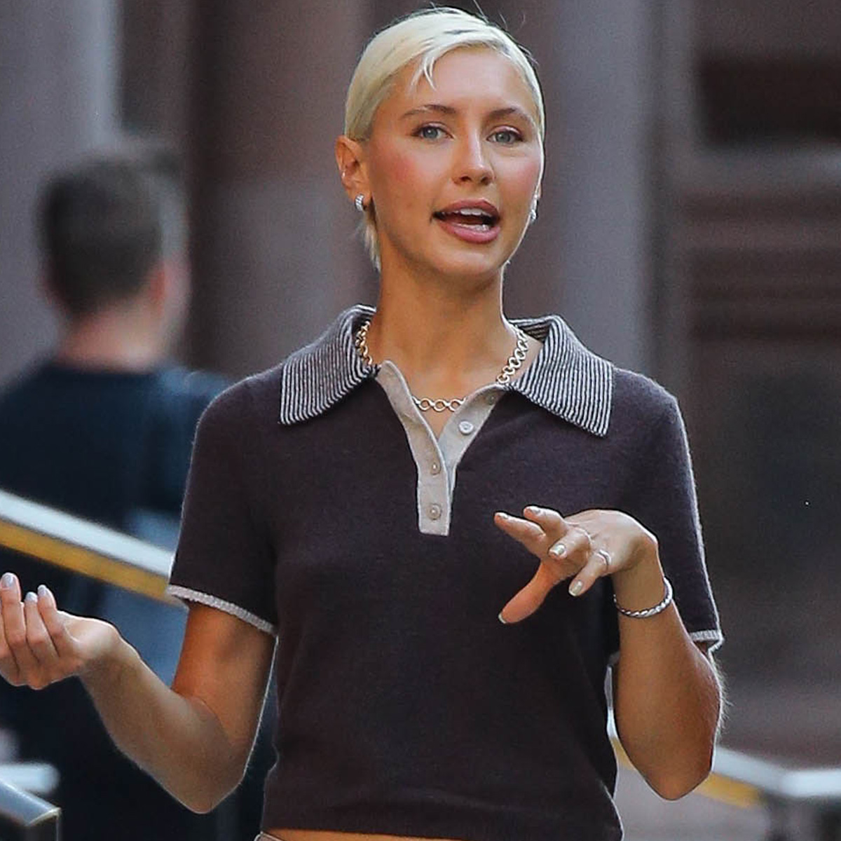 Iris law wears a brown polo shirt.