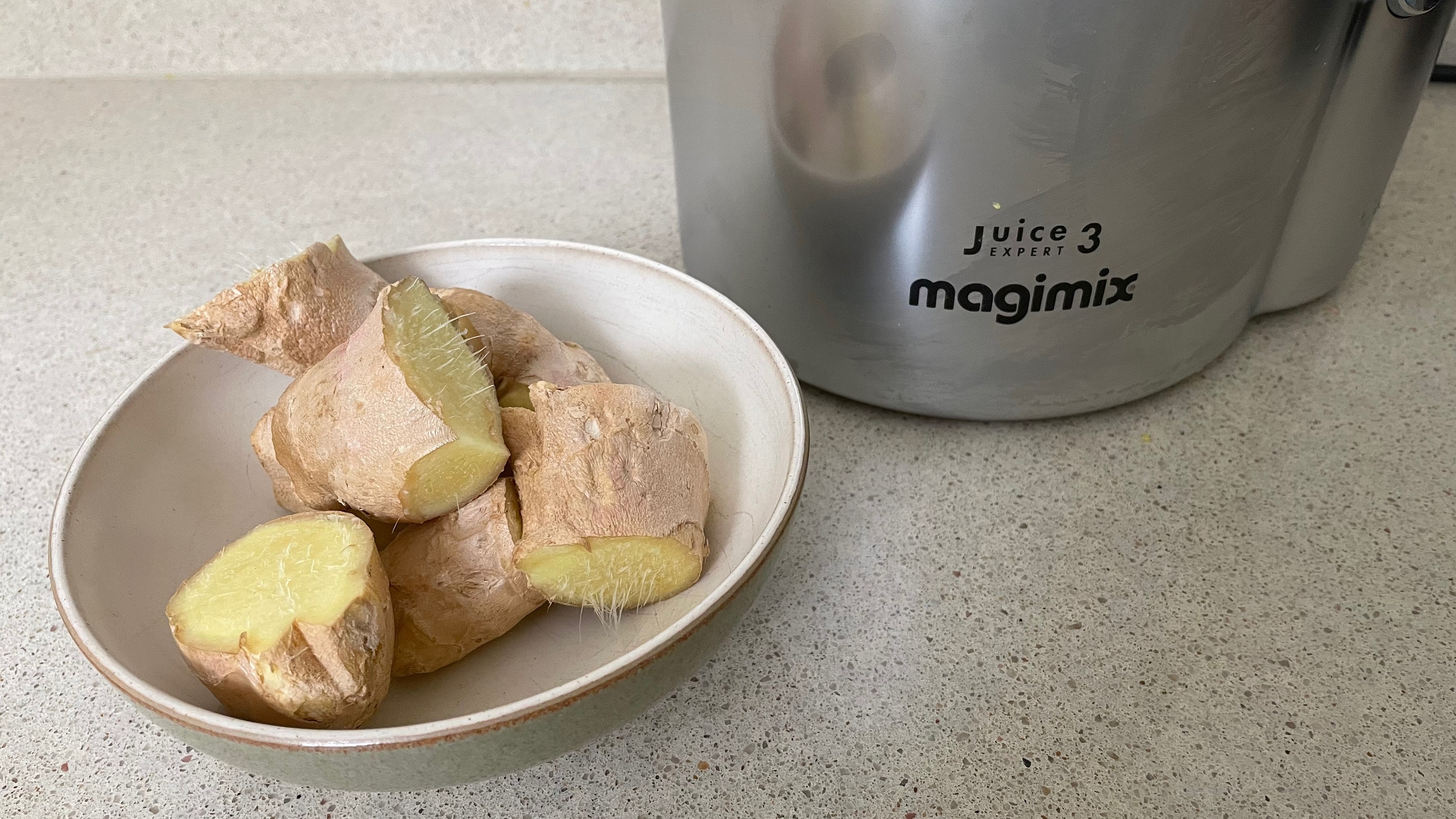 how to juice ginger: ginger pieces next to juicer
