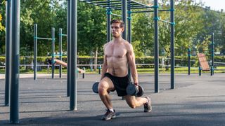 a photo of a man doing a lunge with a dumbbell in each hand 