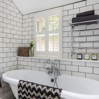 white bricked walled bathroom with bathtub and towel rack