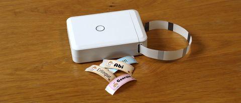 Niimbot D110 review; a small white box printer on a wooden table with colourful stickers