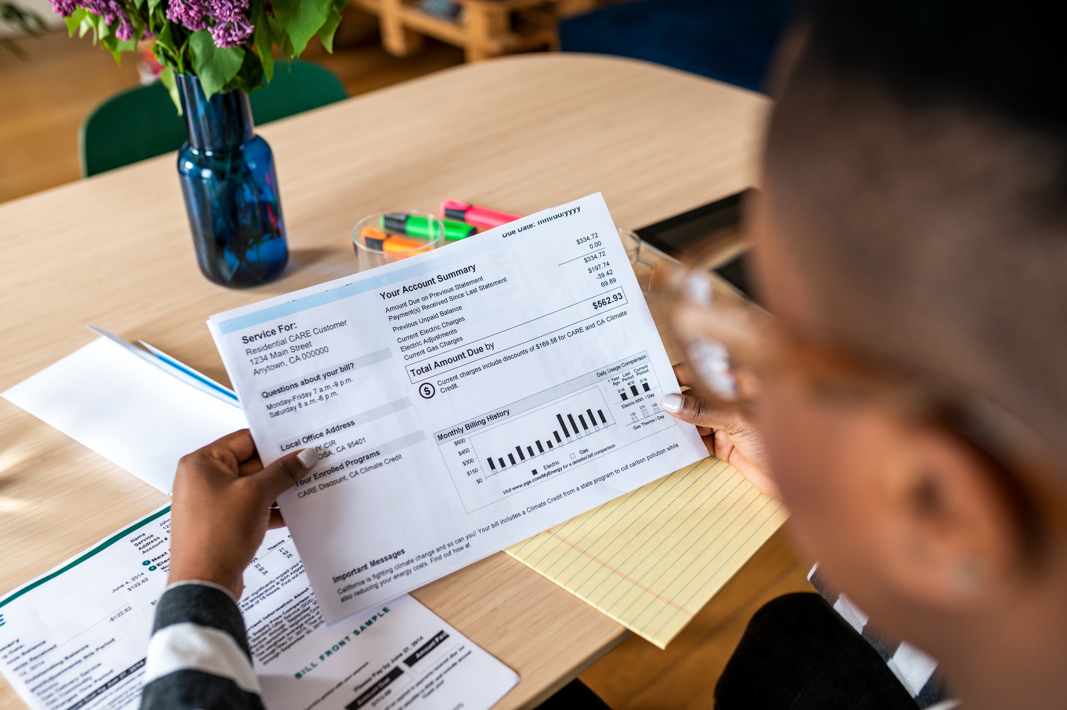 A woman looking at the electricity bill while sitting at a desk
