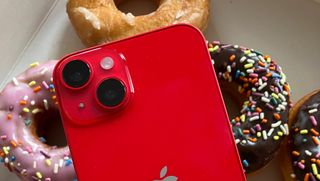 iPhone shown over donuts in bright red color