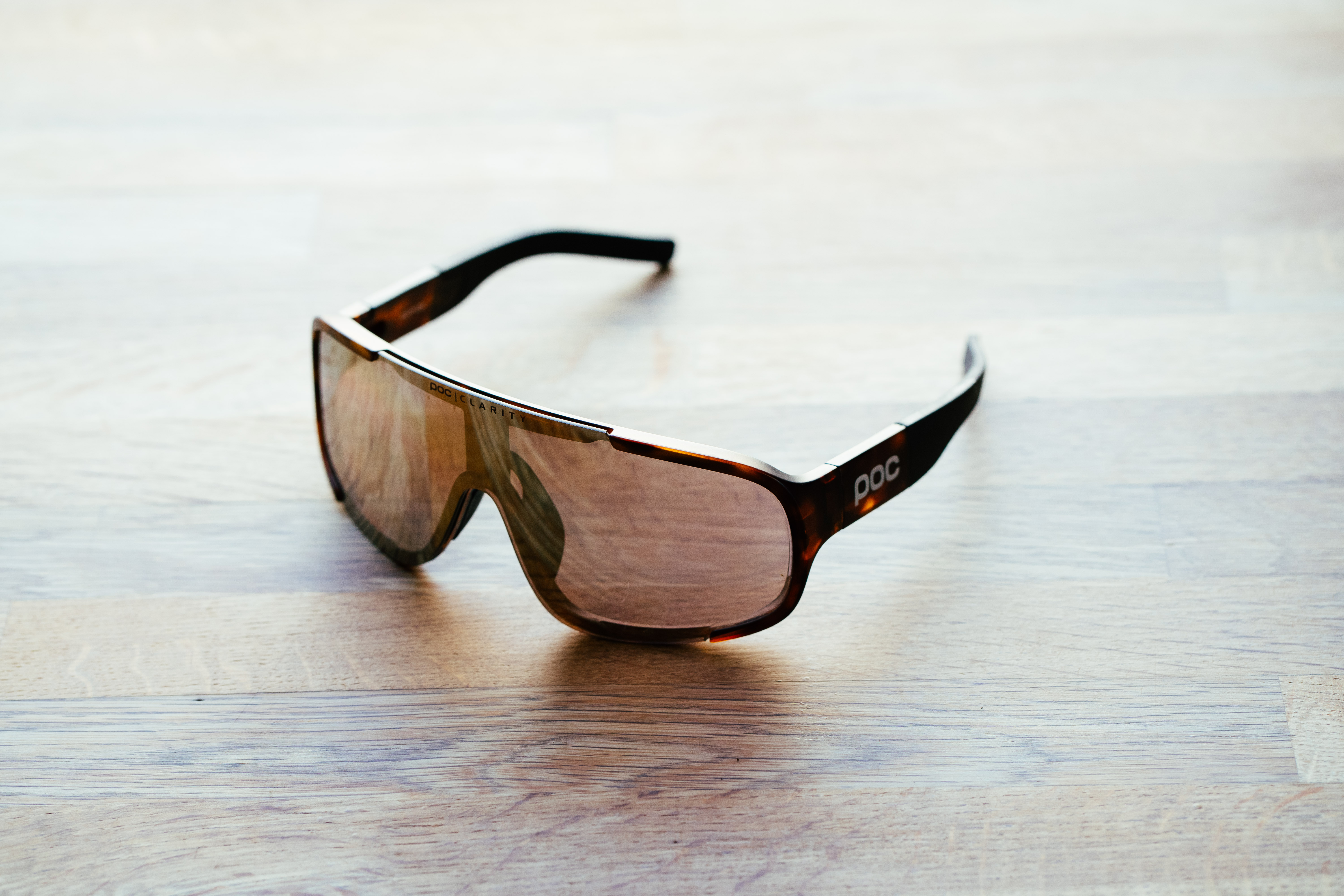A tortoiseshell set of sports glasses on a wooden surface