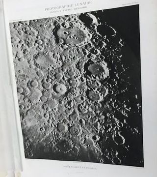 a photograph of the moon in a book. a French title is on the top