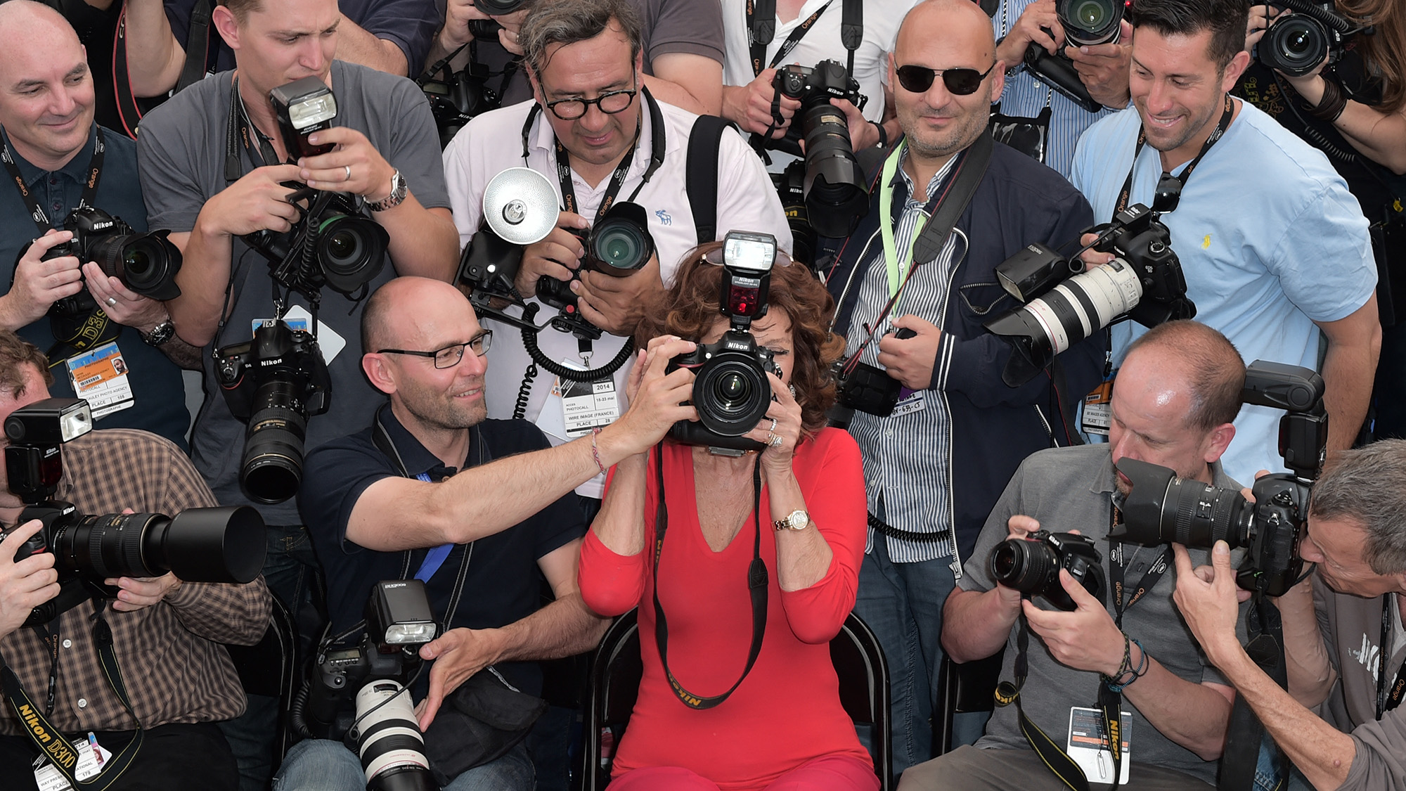 Italian actress Sophia Loren (C) holds a professional camera as she sits among photographers during a photocall for "Voce Umana" at the 67th edition of the Cannes Film Festival in Cannes, southern France, on May 21, 2014.