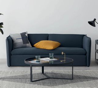 sofa with cushion grey wall and table with glass