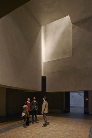People looking towards the ceiling in a dark room