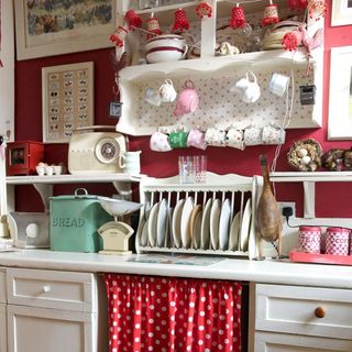 open kitchen storage with ditsy floral wallpaper and white washed shelves