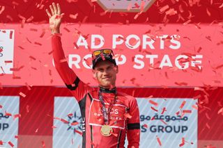 Lucas Plapp of Ineos Grenadiers team celebrates on the podium after being awarded the red jersey on the second stage of the UAE cycling tour, in Abu Dhabi on February 21, 2023. (Photo by Giuseppe CACACE / AFP) (Photo by GIUSEPPE CACACE/AFP via Getty Images)