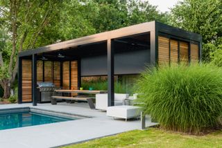 modern garden room next to a pool with an outdoor seating area and BBQ