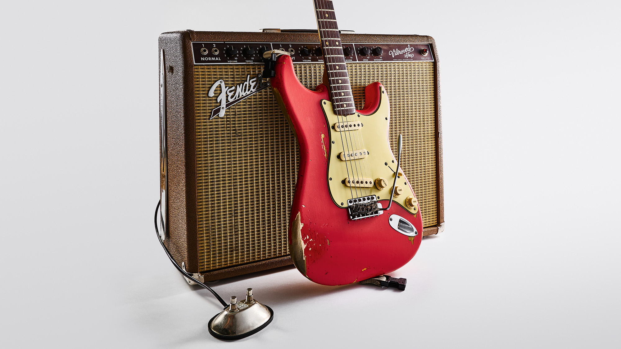 Gary Moore&#039;s Red Strat, photographed in front of a vintage Fender amp