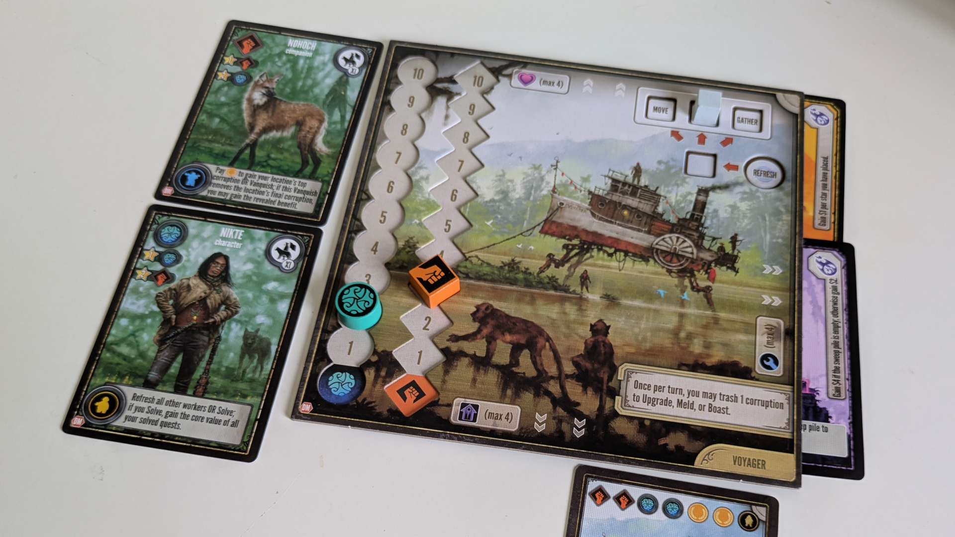 A tracking board and tokens from Duel of Meloch, with cards on either side and below