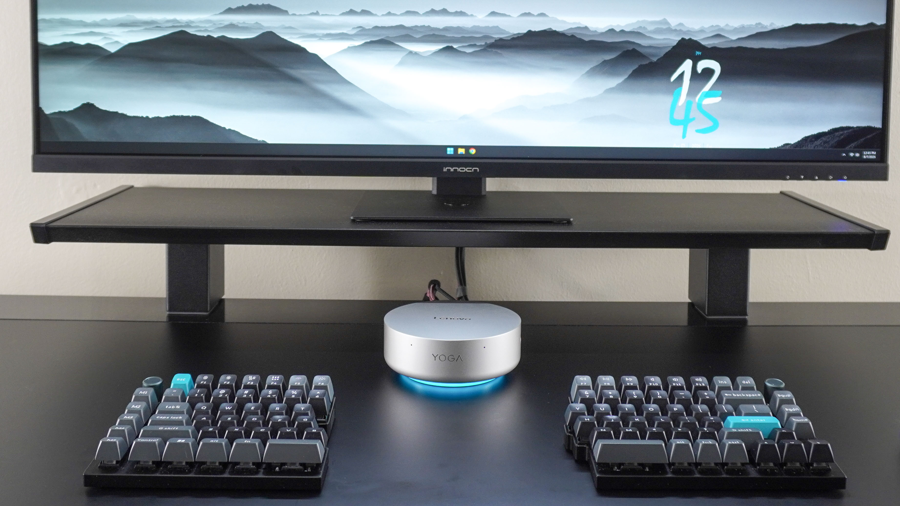 A desk setup built around the Lenovo Yoga Mini with the mini PC in between two halves of a split mechanical keyboard