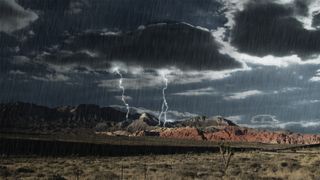 A desert landscape where there is a thunderstorm, thick clouds and lightning can be seen
