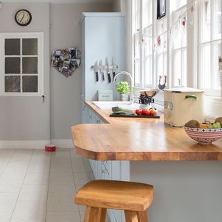 kitchen with white windows and wood worktops with stool