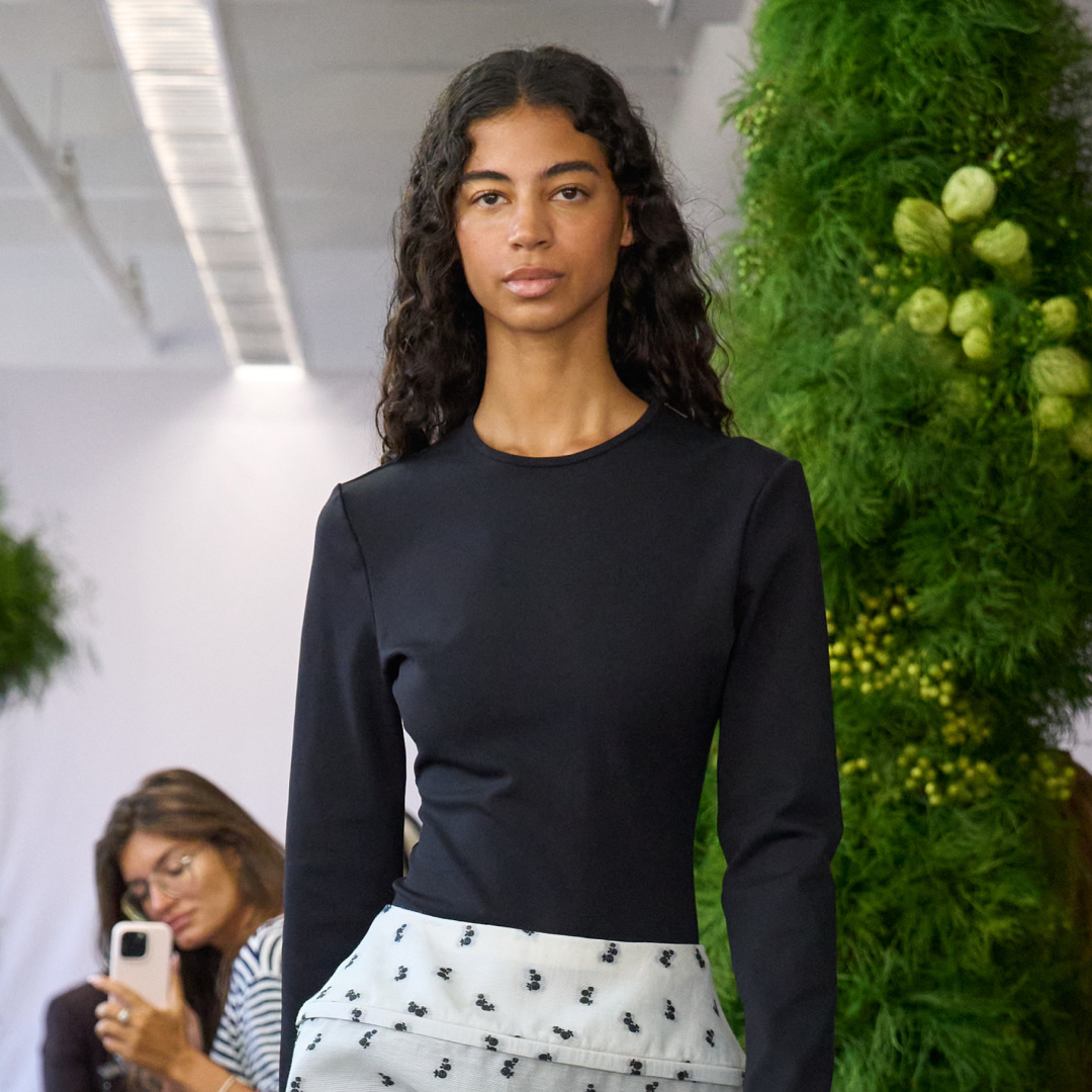 a tibi model wearing a polka dot skirt and a black sweater