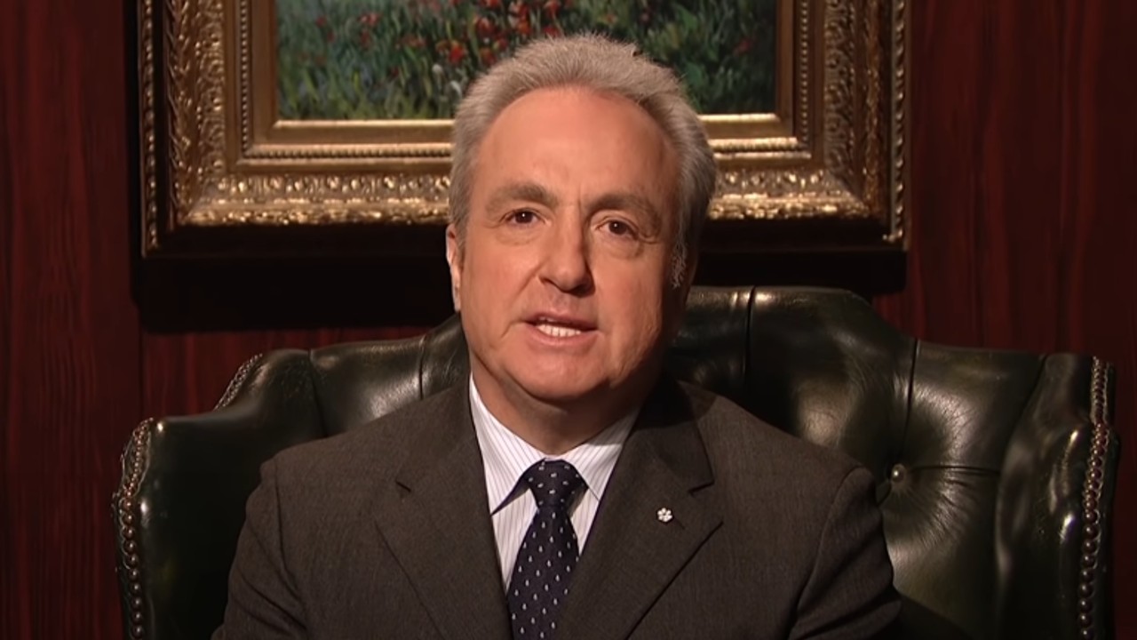 Lorne Michaels sitting in a chair during a cold open on Saturday Night Live in 2013.