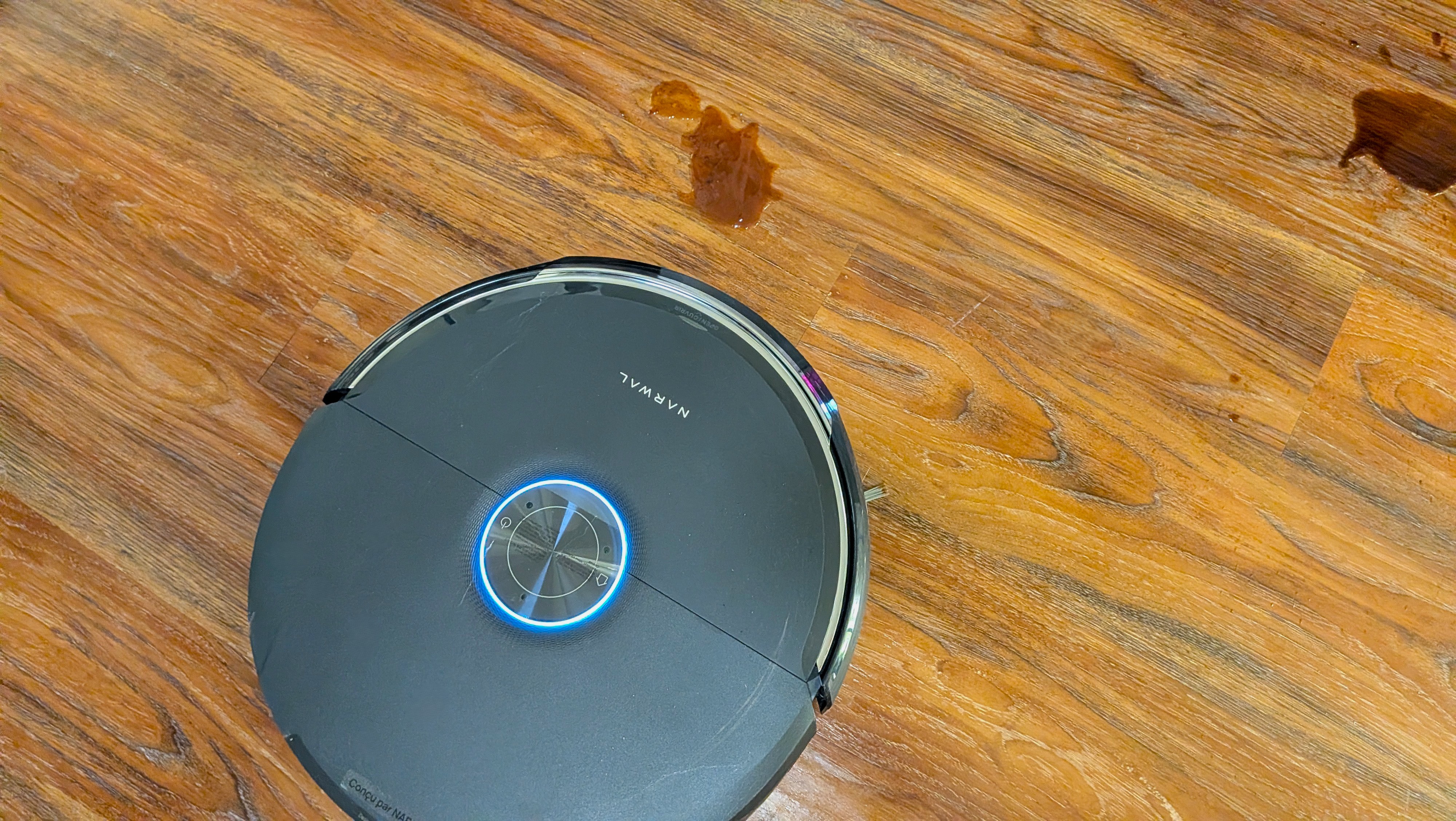 Narwal Flow 2 robot vacuum cleaning up wet spill on hard floor