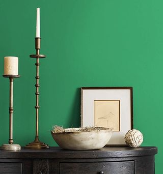 green wall with dark wood console table