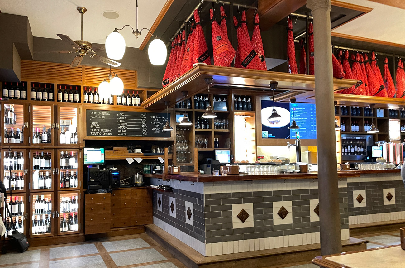 Shelves of wine and a food counter in a restaurant