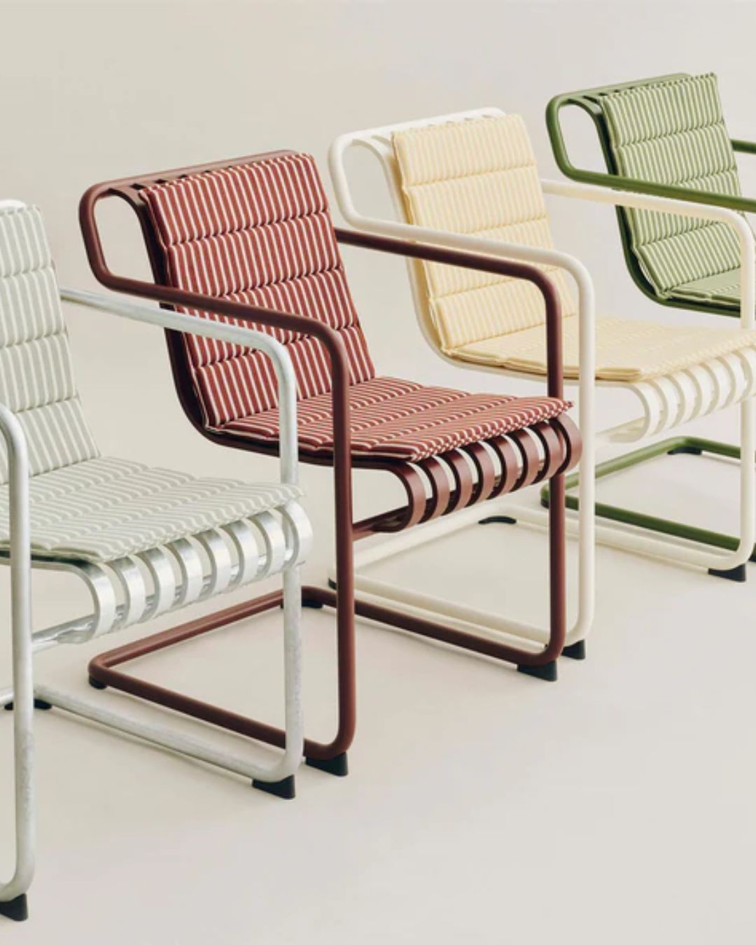Hay Terrazza Folding Seat Cushion, styled across multiple chairs in white, red, yellow, and green, against pale beige background.