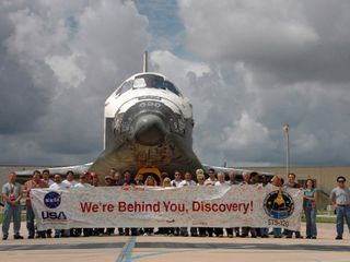 The vehicle processing team says a final goodbye and gathers for a photo in front of space shuttle Discovery after its exit from the Orbiter Processing Facility bay 3 in preparation for launch to the International Space Station for mission STS-120. This i