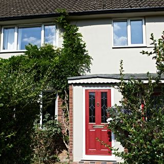 exterior with white wall and red door with plants