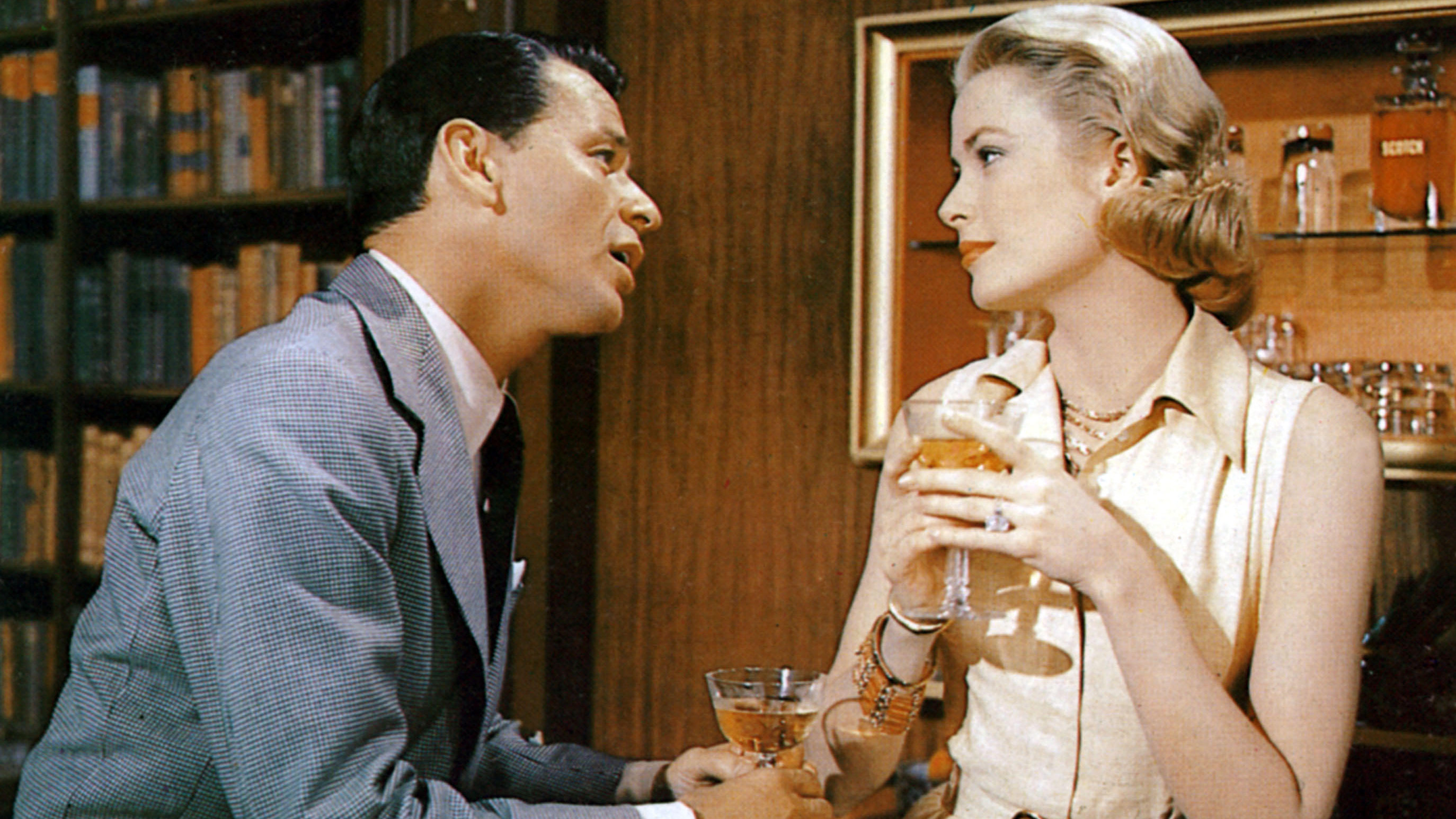 Frank Sinatra and Grace Kelly in High Society drinking cocktails in a library 