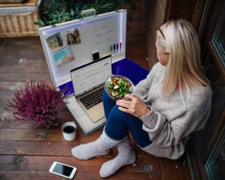 Woman sat outside using a portable workspace in a box!