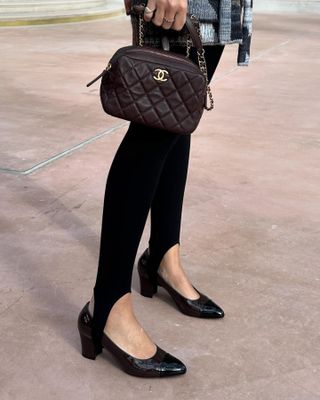 Fashion influencer @jen_wonders wearing a chic winter outfit with black stirrup leggings.