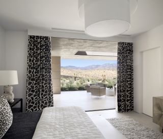 A bedroom overlooking a porch with a desert view and seating arrangement